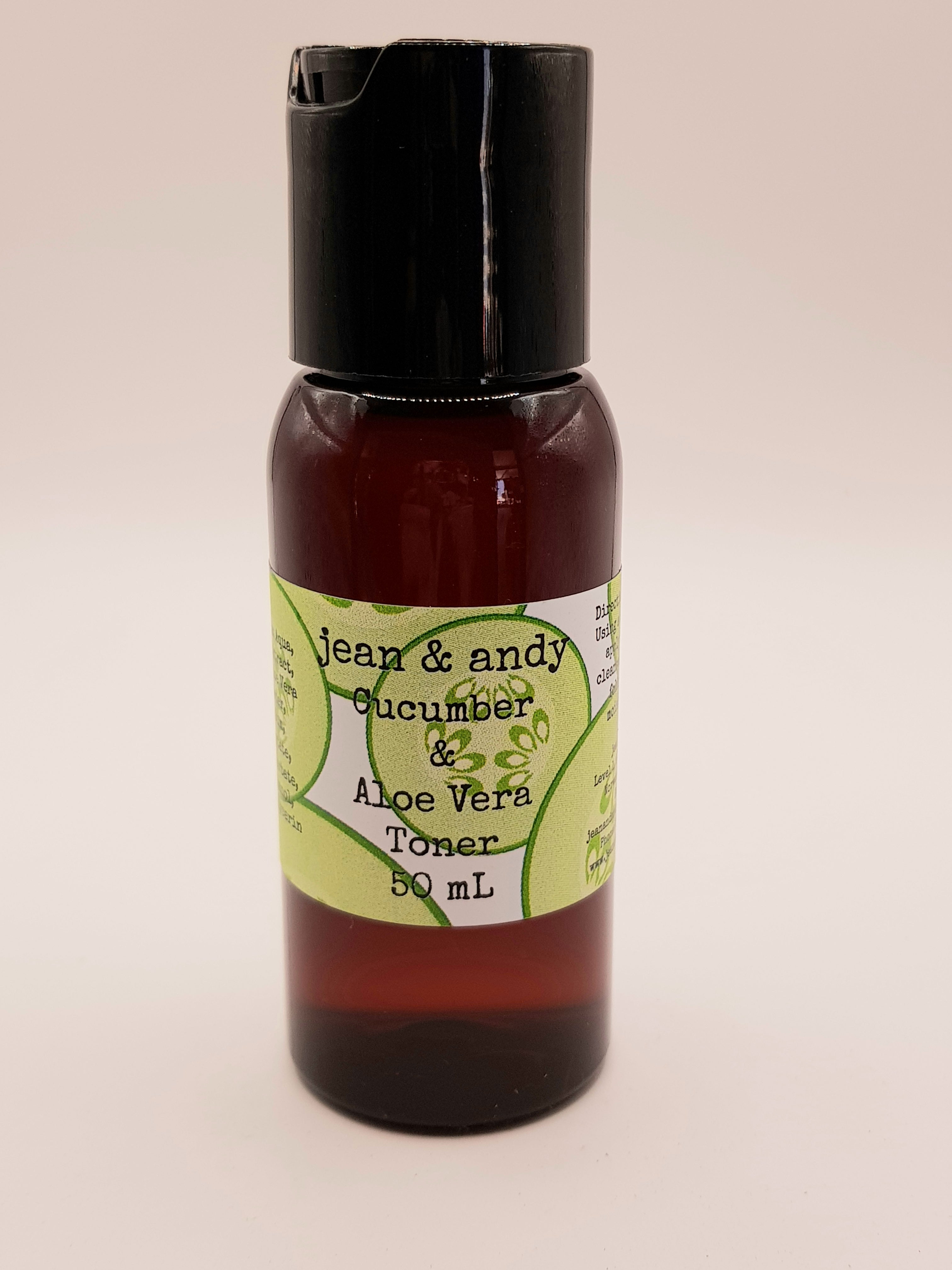 A petite 50 mL brown bottle of Tweens Cucumber Toner from jean & andy, infused with Aloe Vera gel and adorned with a green label, showcases its refreshing essence as it rests against a neutral off-white background, complete with a black cap.