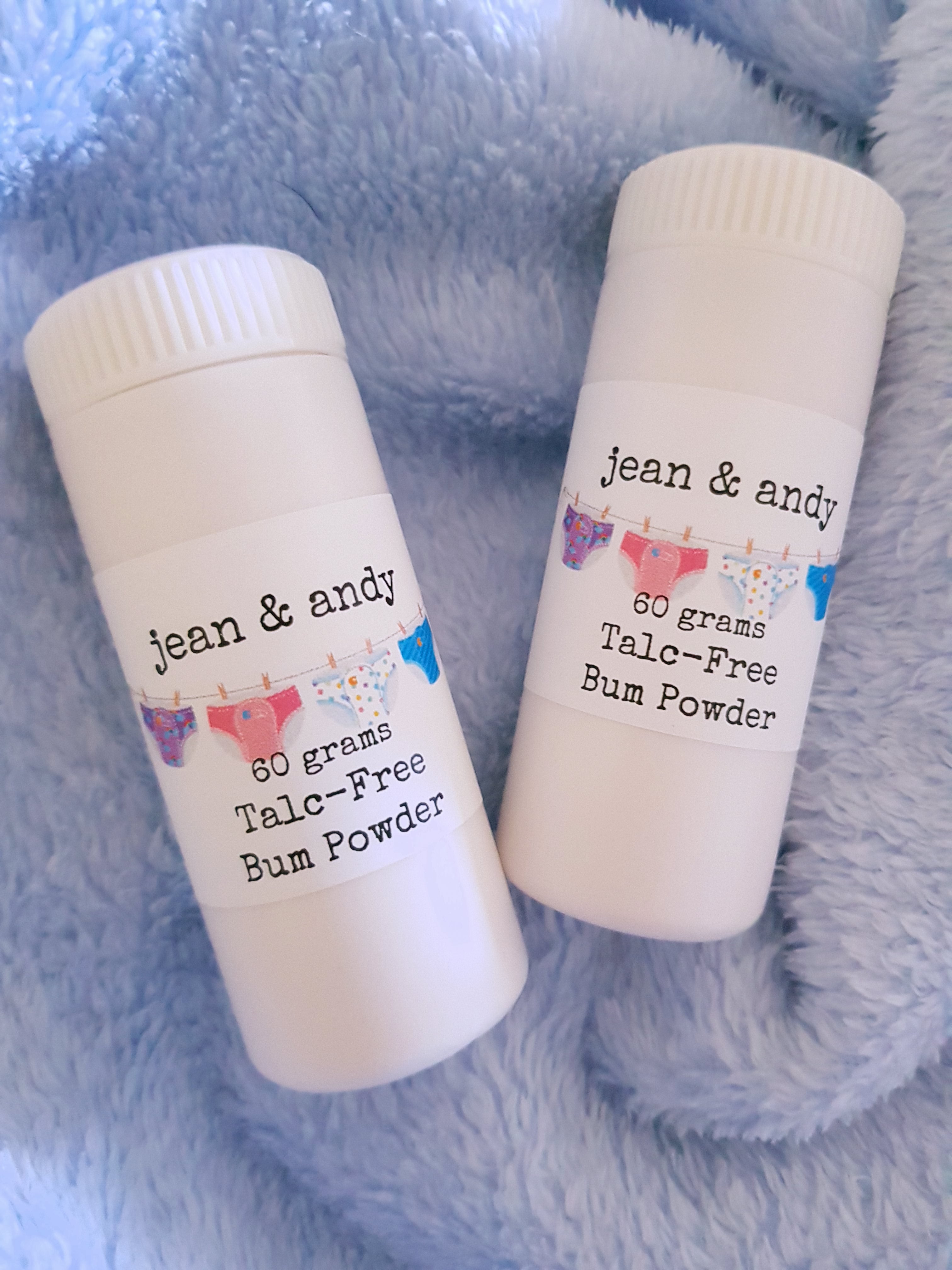 "A 60-gram bottle of Baby Bum Powder featuring a talc-free, non-toxic formula with corn starch, calamine powder, kaolin clay, and chamomile, designed for convenience and safe use."