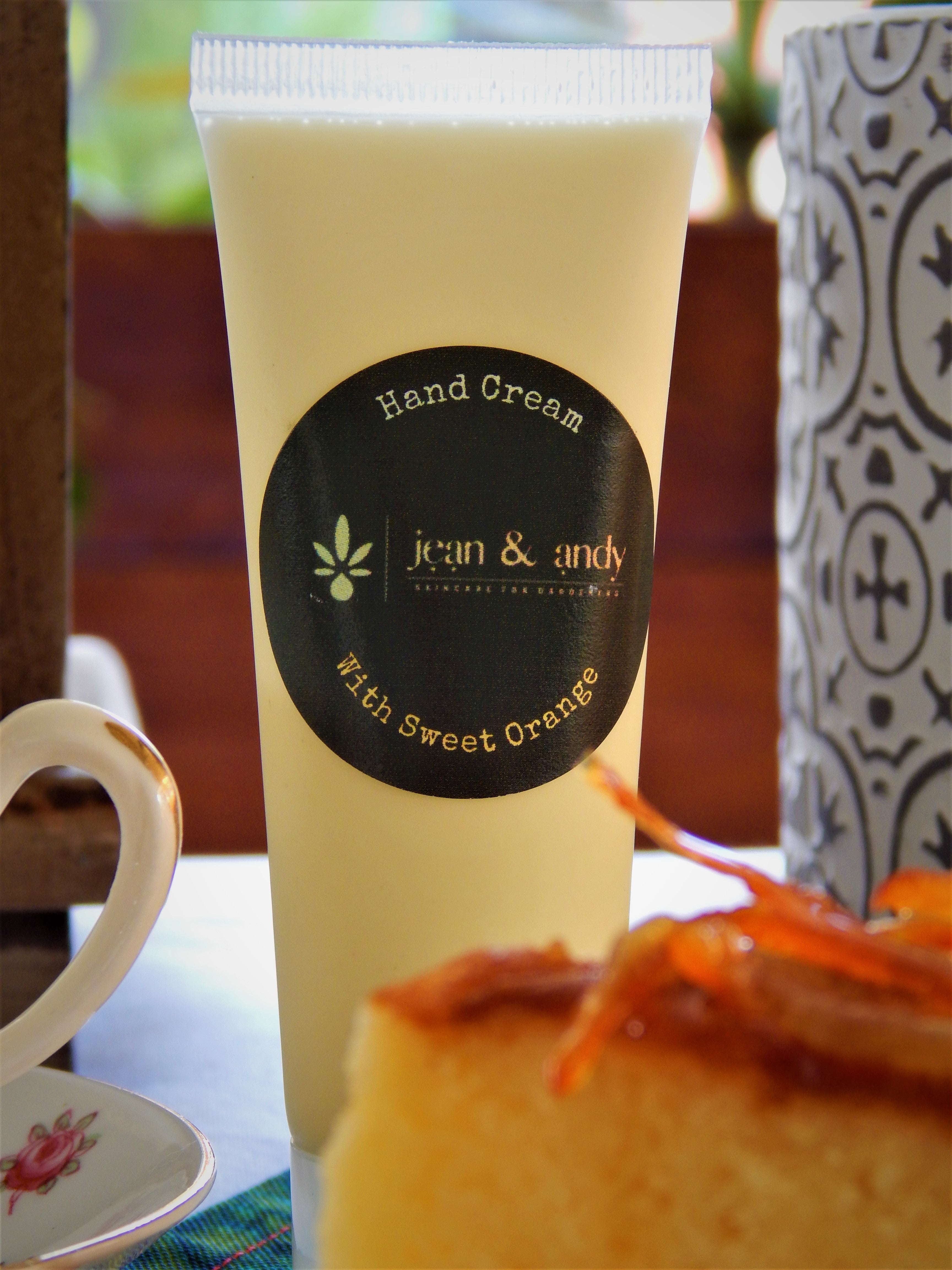 Sweet Orange Hand Cream with tea and cake in the background